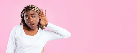 Curious black woman holding hand near ear