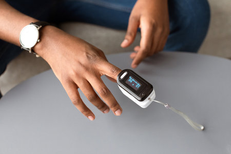 Closeup Of Pulse Oximeter Clip On Black Man Hand, Croppedの写真素材