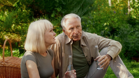 Seniors enjoying a peaceful moment in a lush green gardenの写真素材