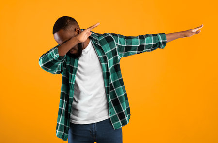 Black Guy Throwing Dab Gesture Posing Standing On Yellow Backgroundの写真素材