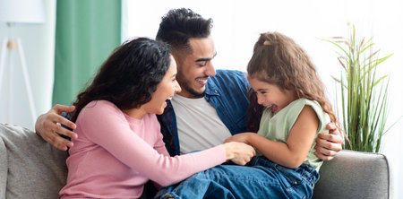 Cheerful Arabic Family Of Three Having Fun At Home, Laughing Togetherの写真素材