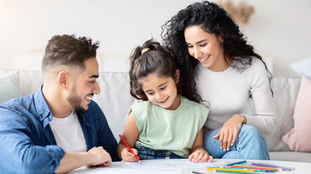 Loving Arab Parents Drawing With Their Little Preschooler Daughter At Homeの写真素材