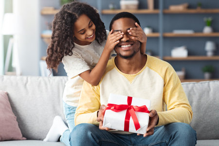 Cute little daughter giving present to her daddyの写真素材