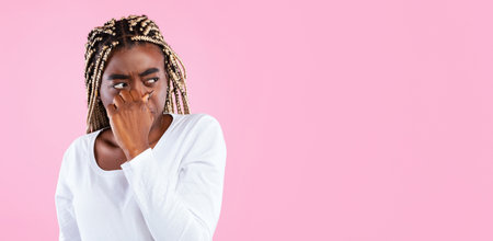 Displeased african american woman plugging her nose, smells something stinkyの写真素材
