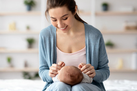Portrait of young beautiful mother bonding with little baby at homeの写真素材