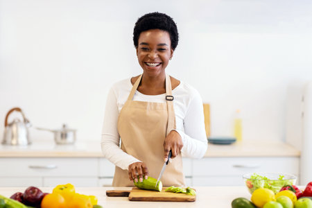 Happy African Housewife Cooking Cutting Zucchini Vegetable In Kitchen Indoorの写真素材