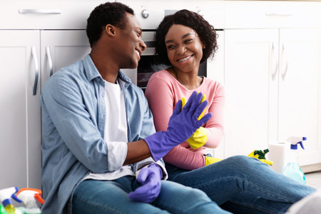 Smiling black man and woman house-keepers giving high fiveの写真素材