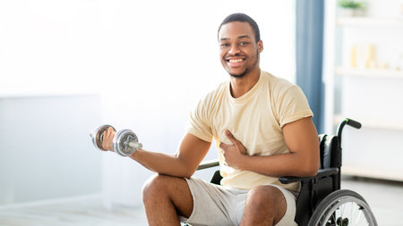 Physical rehabilitation for with disability people. Black guy in wheelchair making exercises with...