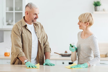 Happy couple enjoying cleaning house together, home hygiene, relationships and domestic lifeの写真素材