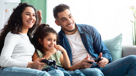 Cheerful Arab Family, Parents And Little Daughter Competing In Video Gamesの写真素材