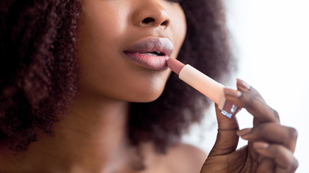 Unrecognizable black lady applying organic matte lipstick, closeupの写真素材
