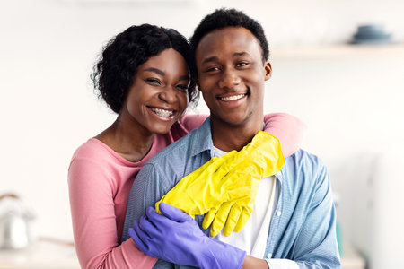 Happy black lovers embracing while cleaning houseの写真素材