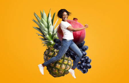 Cheerful woman jumping amidst vibrant fruits on a bright backgroundの写真素材