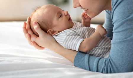 Joy Of Motherhood. Happy Young Mom Relaxing In Bed With Newborn Baby