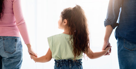 Family Support Concept. Little Girl Holding Hands With Mom And Dad, Closeupの写真素材
