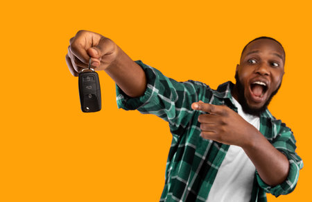 Black Man Showing New Car Key Posing On Yellow Backgroundの写真素材
