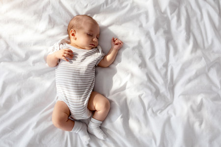 Top View Shot Of Adorable Little Newborn Baby Sleeping In Bedの写真素材