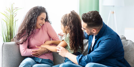 Loving Arabic Family Of Three Bonding At Home, Having Fun Togetherの写真素材