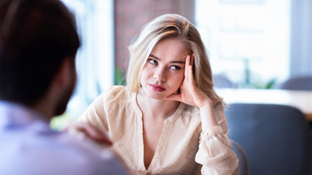 Young Caucasian woman disinterested in blind date, feeling bored with conversation at city cafe