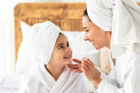 Mom putting make up on her cute little daughterの写真素材