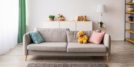 Comfy sofa with pillows, soft carpet, shelves with various accessories and large window in living room interiorの写真素材