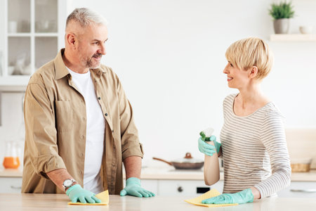 Happy couple enjoying cleaning house together, home hygiene, relationships and domestic lifeの写真素材