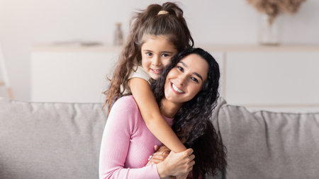 Portrait Of Cute Little Girl And Her Mom Embracing At Homeの写真素材