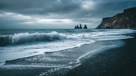 Waves crash onto a black sand beach with dramatic rocky cliffs in the background during twilightの素材
