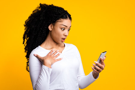Shock Content. Dazed African American Woman Looking At Smartphone Screen
