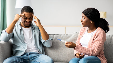 Confused black lady showing her stressed boyfriend pregnancy testの写真素材