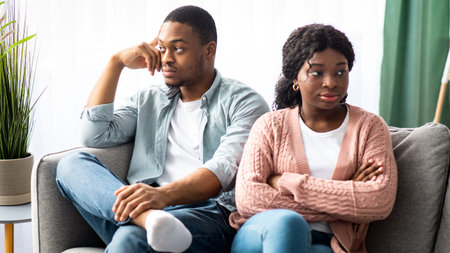 Angry black woman sitting apart from her frustrated boyfriendの写真素材