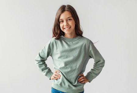 Cheerful Preteen Girl Posing With Hands On Hips, Gray Backgroundの写真素材