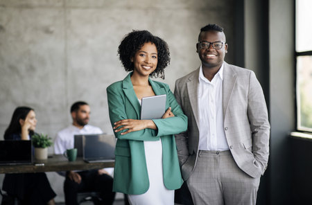 Happy Couple Of Black Coworkers Posing At Modern Office Interiorの写真素材