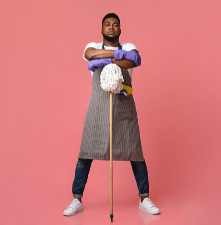 Professional African American Cleaner Posing With Mop Over Pink Backgroundの写真素材