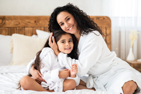 Cheerful young mother hugging her little daughterの写真素材