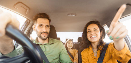 Family car trip, woman pointing out, driver focusedの写真素材