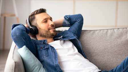 Handsome bearded man in headphones listening to musicの写真素材