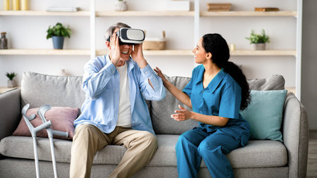 Elderly man using VR headset with young medical worker, exploring augmented reality at retirement homeの写真素材