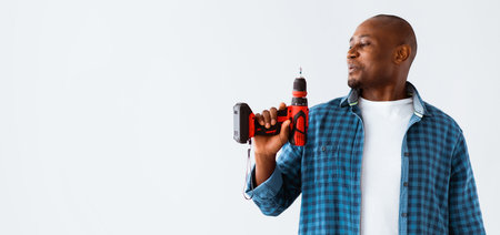 Equipment and tools for repair home. Black man blowing into electric drill like pistol, isolated on...