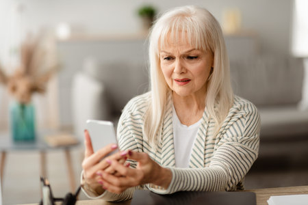 Shocked senior woman using her mobile phoneの写真素材