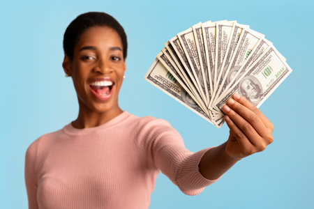 Big Prize. Happy Young African Woman Demonstrating Dollar Cash Fan At Cameraの写真素材