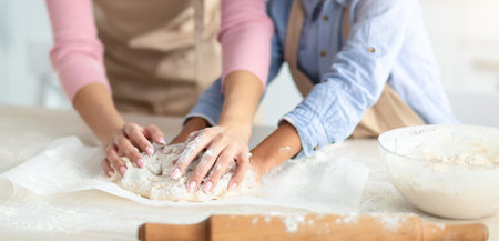 Happy black woman and daughter kneading dough