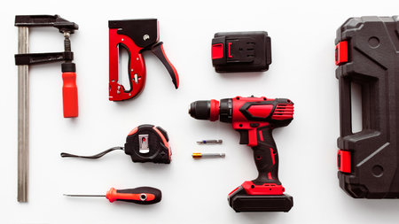Set of various instruments on white background, top view. Tool case, electric drill, ruler and clamp tools, flat layの写真素材