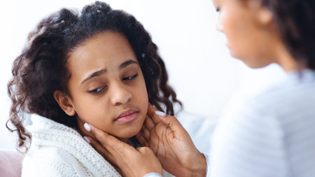 African american mother rubbing her sick daughter neck