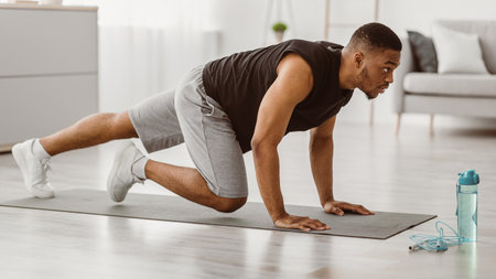 Sporty African Man Doing Running Plank Exercise At Home, Side-Viewの写真素材