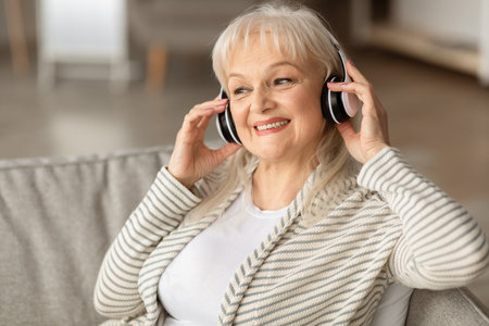 Satisfied smiling mature woman listening to musicの写真素材