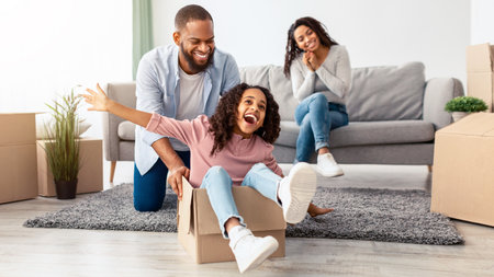 Happy black family celebrating moving day in new flat