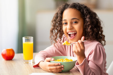 Happy african american girl having healthy breakfast and reading book