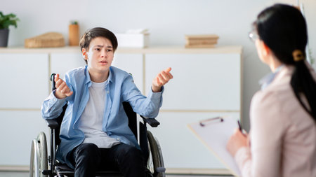 Professional psychological help for disabled teens. unhappy handicapped adolescent talking to psychotherapist at officeの写真素材