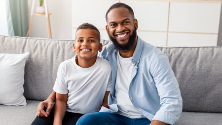 Portrait of black father and son hugging on couchの写真素材